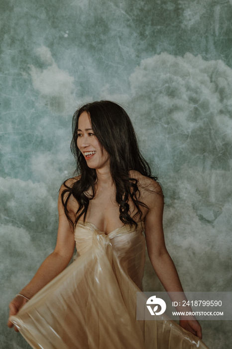 portrait of a Chinese woman laughing wearing white fabric