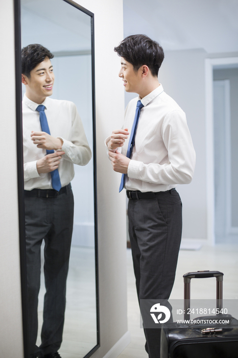 年轻男子在镜子前检查着装