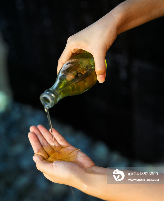 Woman pouring essential oil on her hand