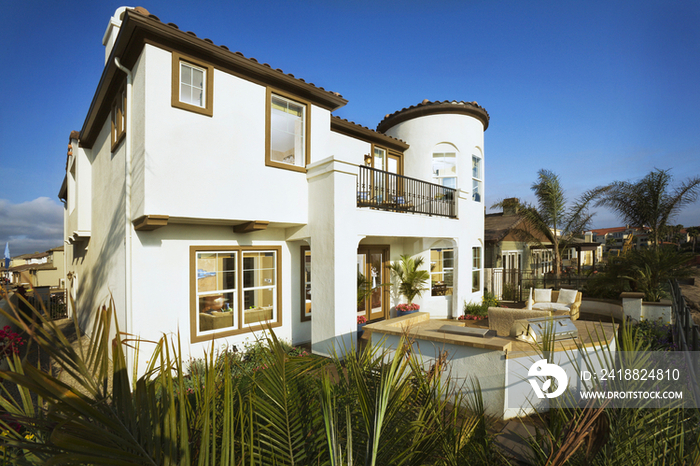 Rear exterior of one story house with patio against clear blue sky; Oxnard; California; USA