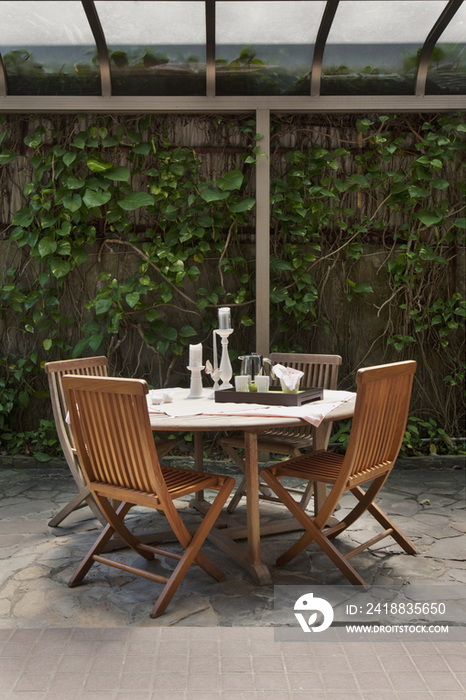 Veranda table and wooden chairs in house garden