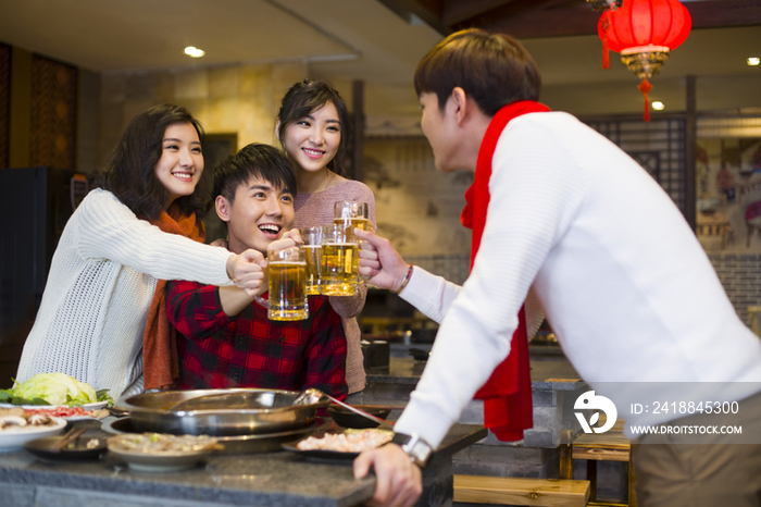 年轻朋友们在火锅店吃饭喝啤酒