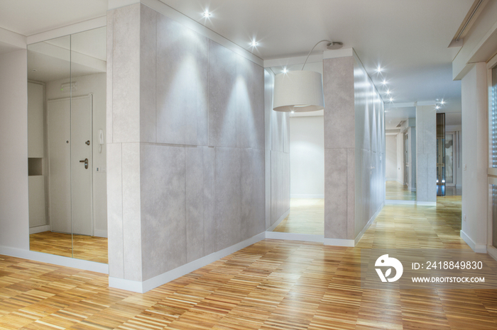 Empty showcase interior with parquet flooring and lit recessed lights