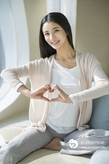 年轻女子摆心形手势