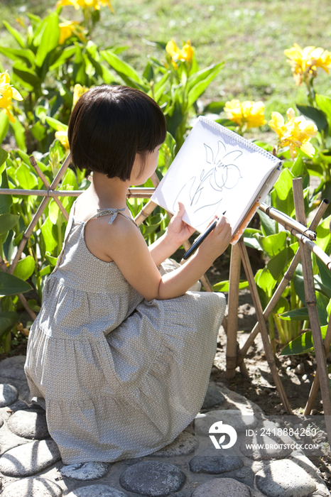 小女孩在花园画画