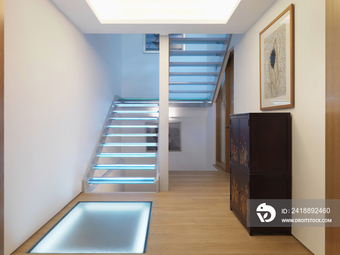 Blue illuminated stairs along parquet flooring hallway at home; Scottsdale; USA