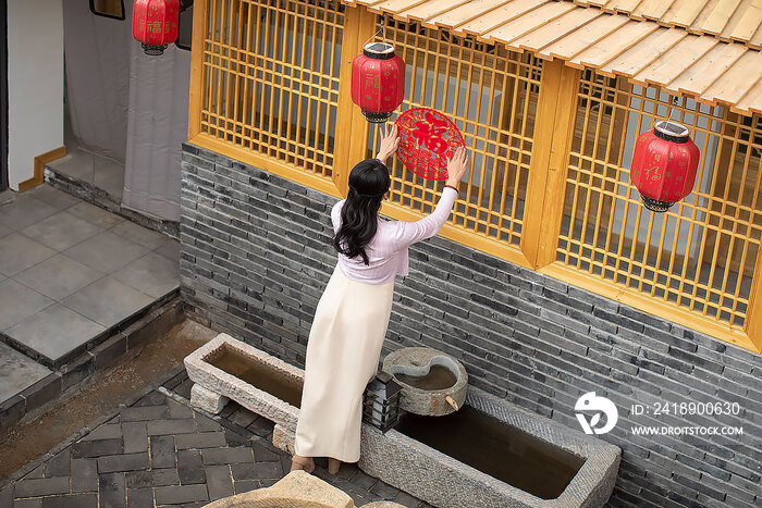 快乐的年轻女子贴窗花迎新年