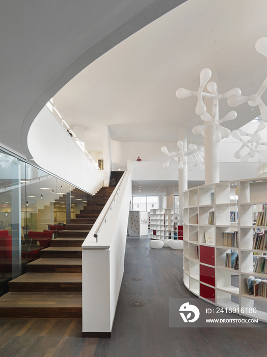 Boy sitting on red modern chair in Openbare Bibliotheek Amsterdam; Amsterdam; North Holland; Nether