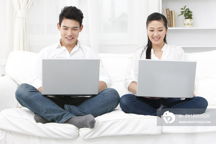 青年夫妇使用笔记本电脑