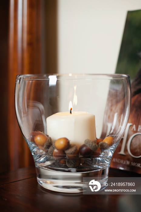 Detail of lit candle in glass holder on table at home; Scottsdale; USA