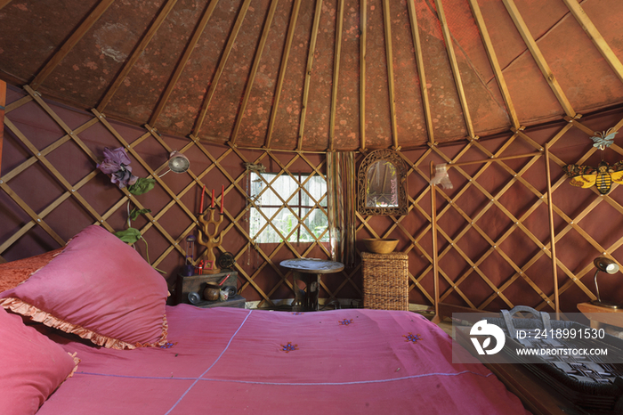 Cropped bed with criss cross designed wall and vaulted ceiling in bedroom at house