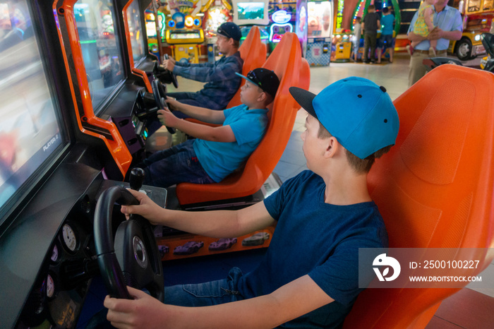 Boys playing game arcade Racing car.