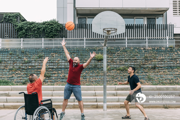 man in wheelchair doing sport with friends