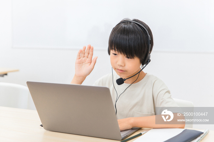 パソコンでテレビ電話・ビデオ通話する小学生の子供