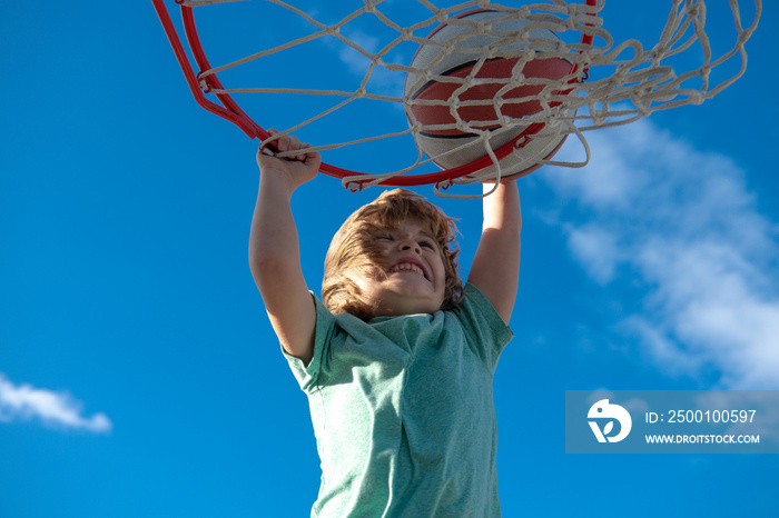 Kid basketball player makes slam dunk. Active kids enjoying outdoor game with basketball.