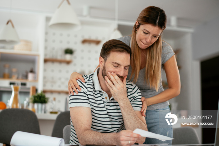 Husband and wife preparing bills to pay. Young couple having financial problems.