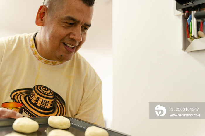 Man holding tray of food to be baked