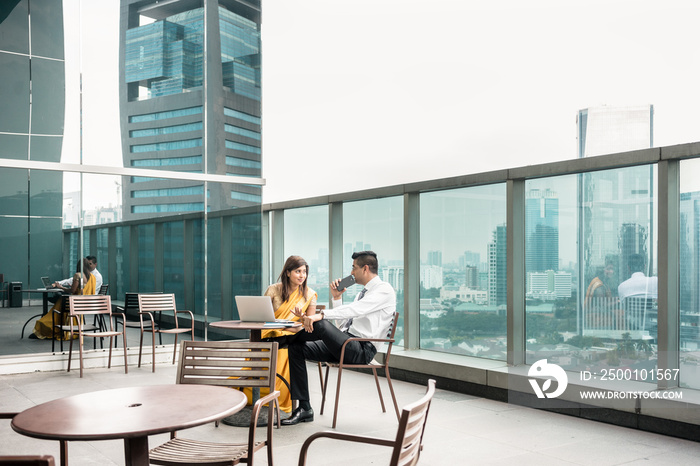 Two colleagues talking on the terrace during break