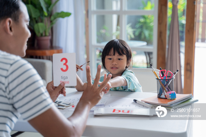 parent showing number on a flash card during studying at home