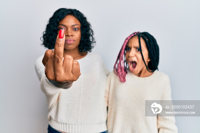 Beautiful african american mother and daughter wearing casual clothes and hugging showing middle finger, impolite and rude fuck off expression