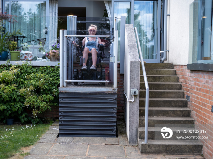 Woman in electric wheelchair using outdoor lift