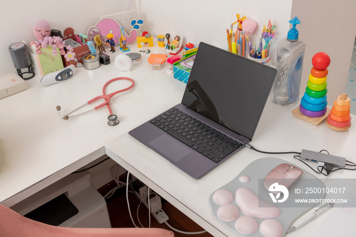 Laptop, stethoscope and pediatric equipment, on the desk of a pediatric office