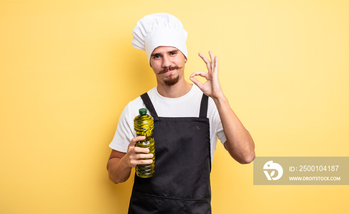 young chef with moustache with olive oil bottle