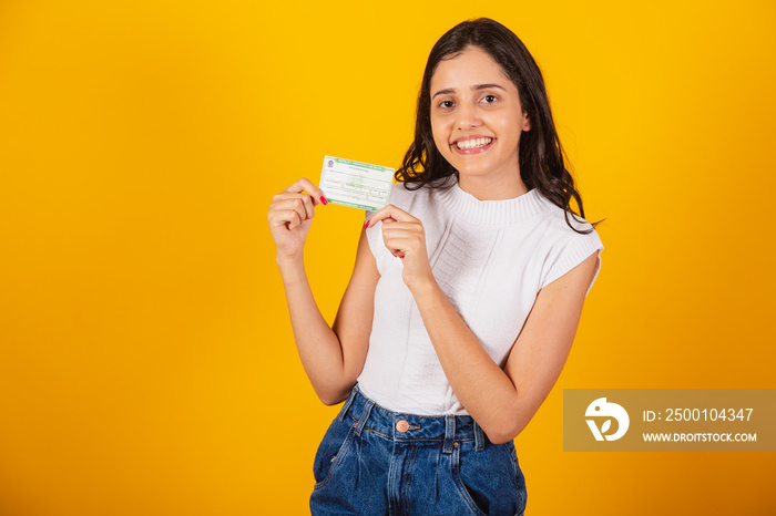 beautiful brazilian woman holding voter registration card.