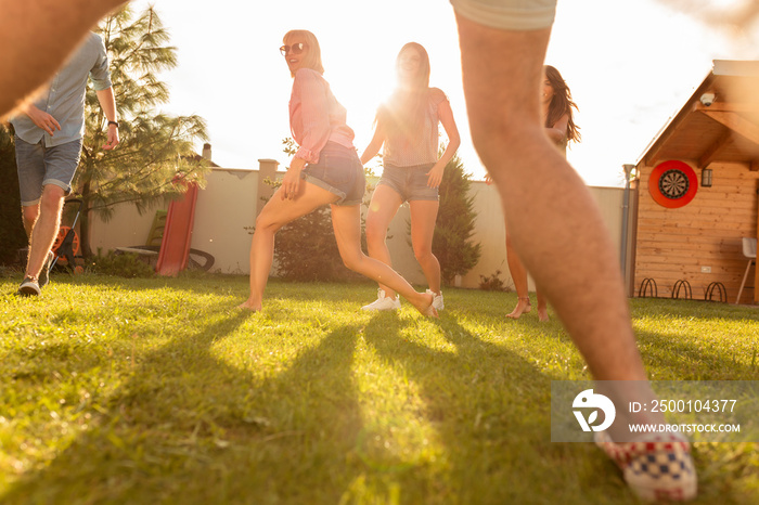 Young people having fun playing football in the backyard