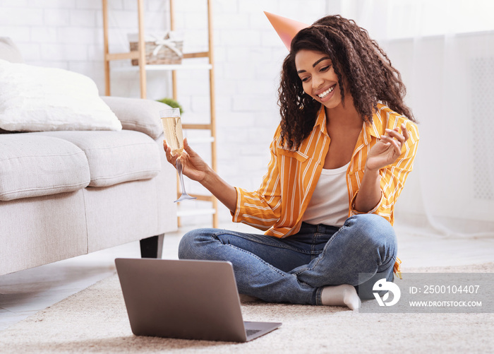 Black woman drinking wine during virtual party