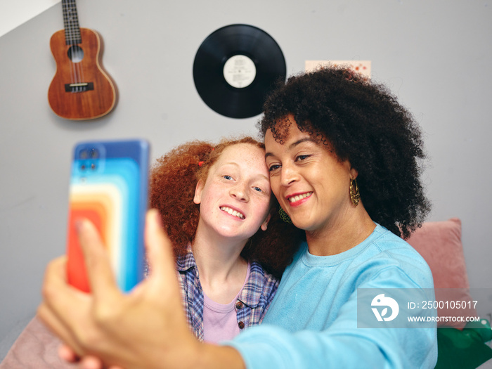 Mother and daughter taking selfie with smart phone