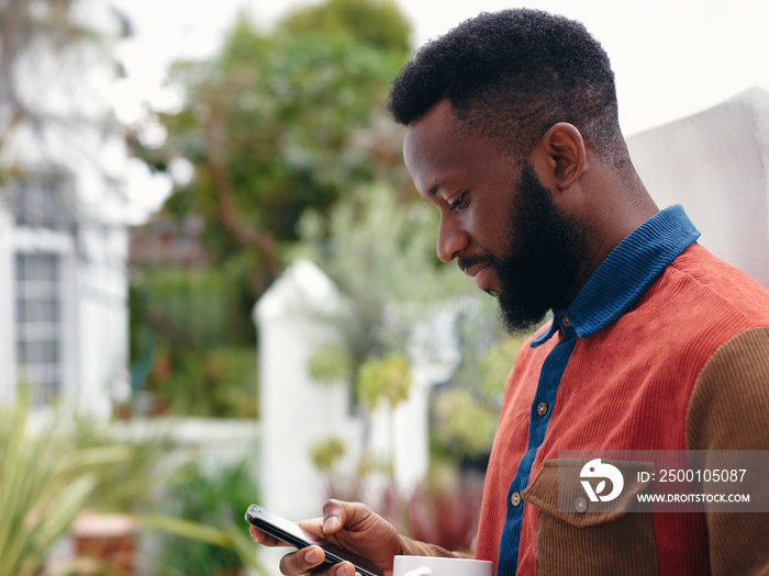 UK, London, Profile of man looking at smart phone outdoors