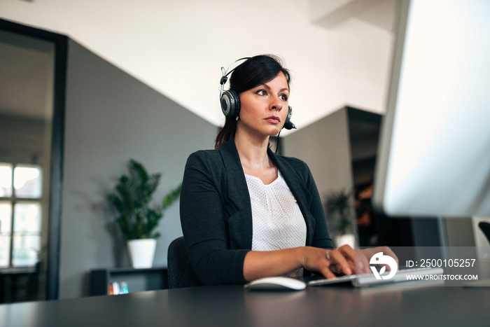 Serious woman working on solving the problem as a customer support.