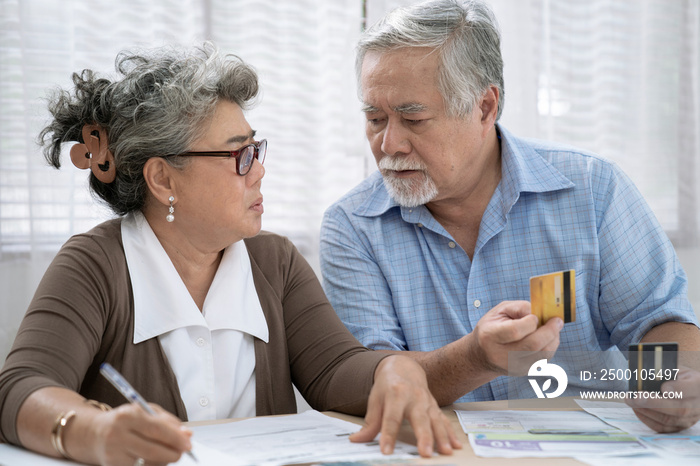 Stressed Asian elderly couple, They are trying to get money to pay off their credit card debt, Financial problems from the coronavirus or covid-19 outbreak.