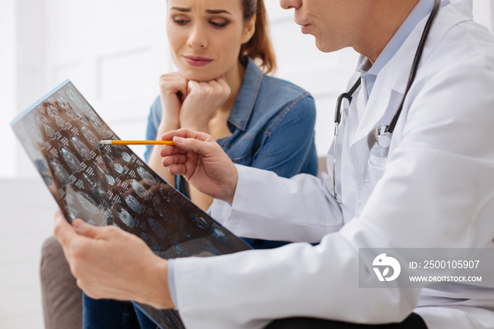 Troubled young lady listening carefully to her doctor