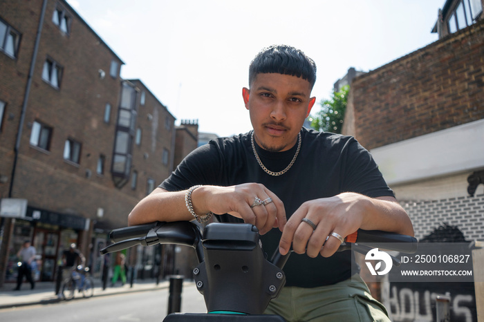 Portrait of man leaning on bikes handlebar