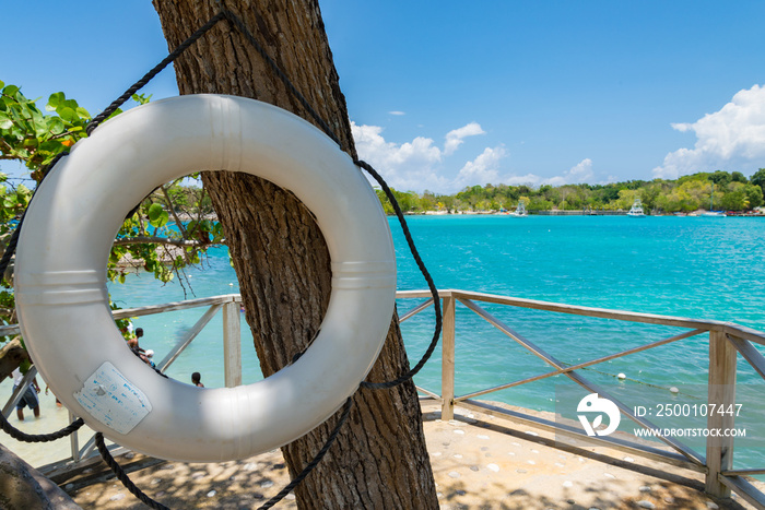 James Bond Beach, Jamaica. A view of the bay, with turquoise waters and green trees in the background. Life buoy in the foreground. Selective focus.