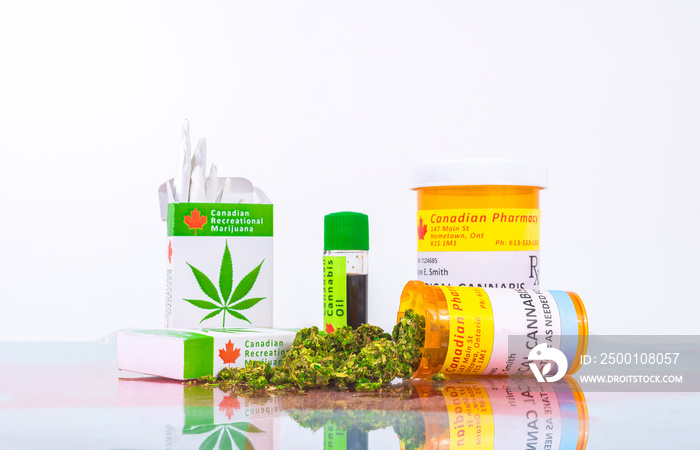 Cannabis in Canada. Marijuana cigarettes, cannabis oil, and prescription bottles for cannabis on a glass table. Buds spill from one of the bottles. Red maple leaf under the glass.