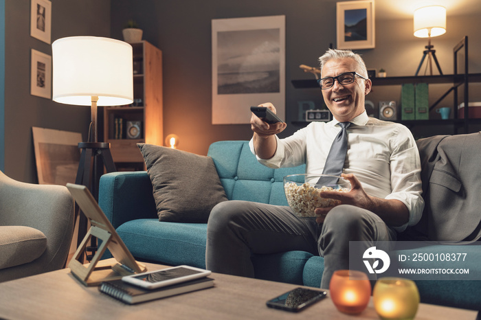 Businessman relaxing on the sofa and watching tv