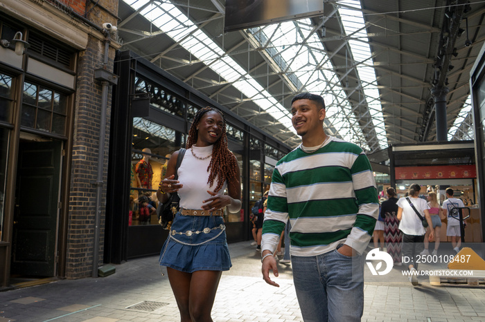 Smiling friends walking in cover market