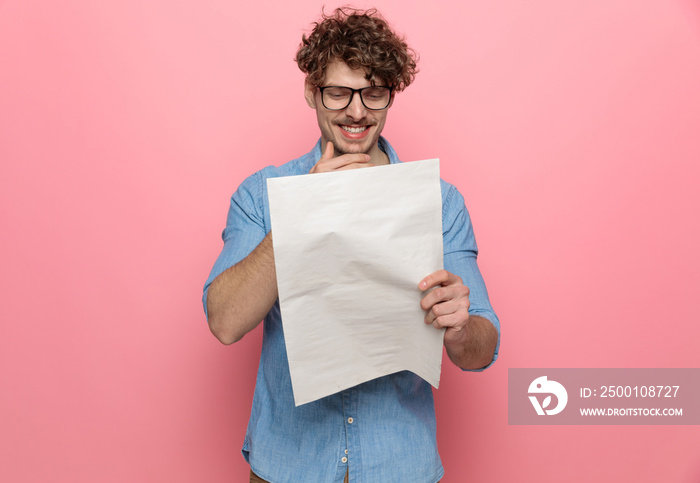 happy young guy laughing and reading newspaper