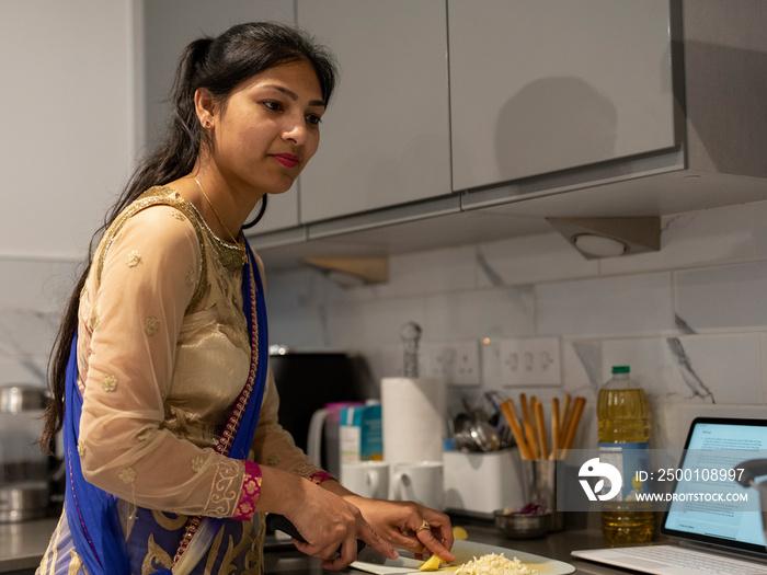 Young woman cooking traditional meal from recipe