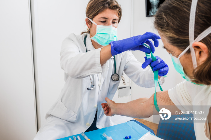 female doctor drawing blood to a patient with risk of infection