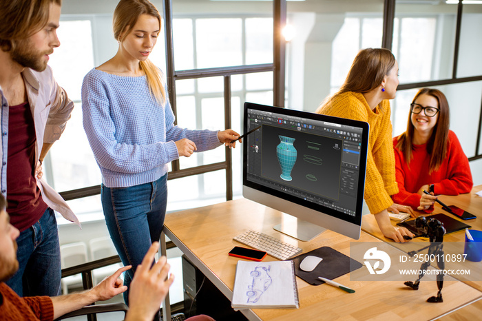 Group of a young coworkers dressed casually modeling 3d project working on computers in the modern office