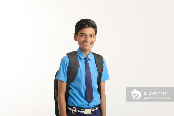 Indian school boy standing on white background.