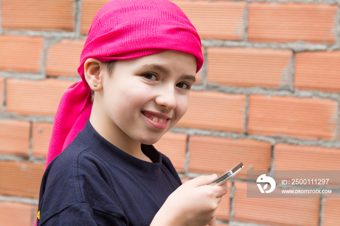 girl sick with cancer and with a headscarf using the mobile phone