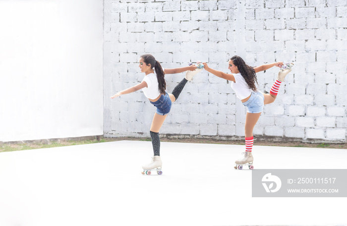 Two Latina teen girls doing a roller skating dance routine