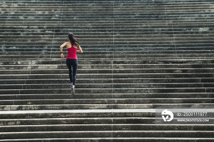 Fitness woman she is running up the stairs.