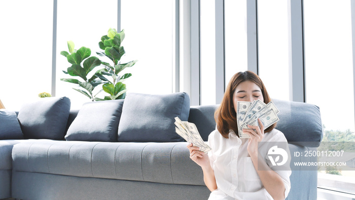 Happy young asian woman holding dollar money and throw in the air celebrate happiness dance wealth lottery money rain drop. Winner Success business woman throw cash flow Happy money smiling face