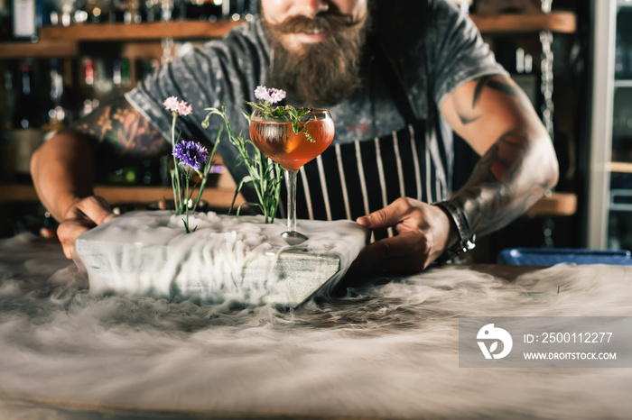 Barman is making cocktail with ice vapor